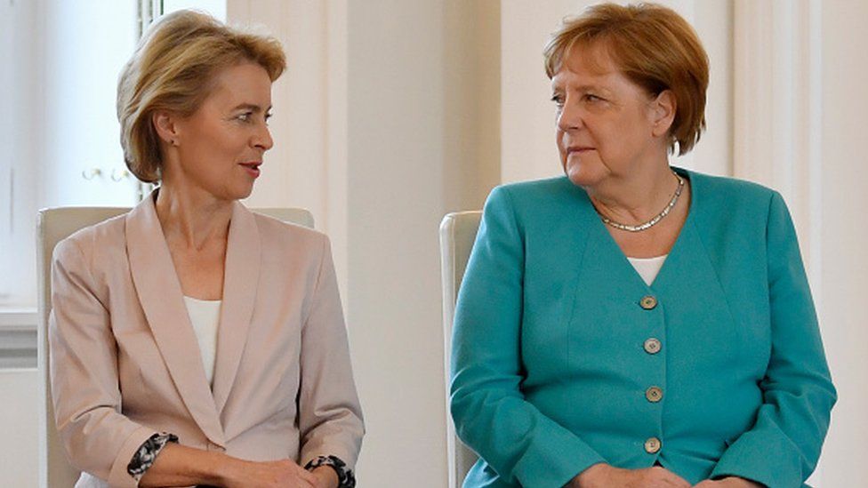 European Commission President Ursula von der Leyen sits next to German Chancellor Angela Merkel