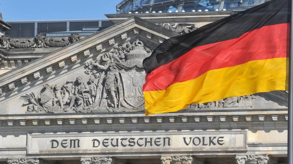 The German flag flying in front of the Reichstag