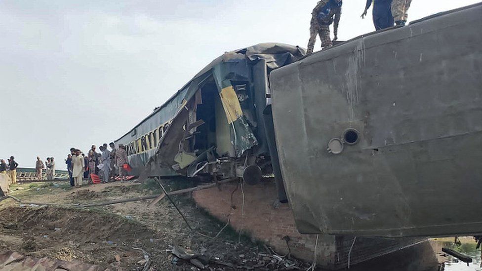 Военизированные рейнджеры осматривают вагоны на месте крушения пассажирского поезда в Навабшахе
