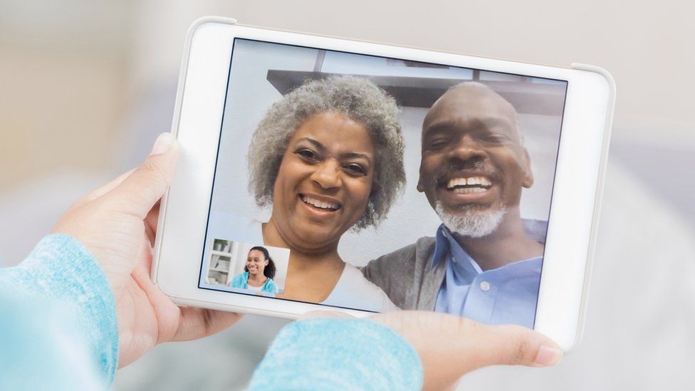 A stock photo shows two older people on a tablet, calling a younger person