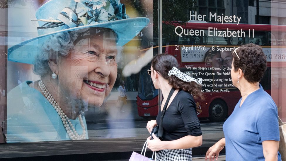 People look at a portrait of Queen Elizabeth II in the window of a shop on Oxford Street in London on 12 September 2022