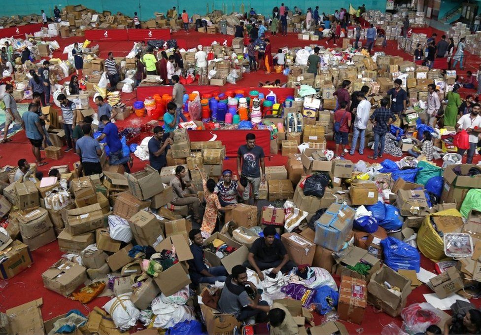 Volunteers organise boxes at an aid distribution centre at a stadium in Kochi, Kerala