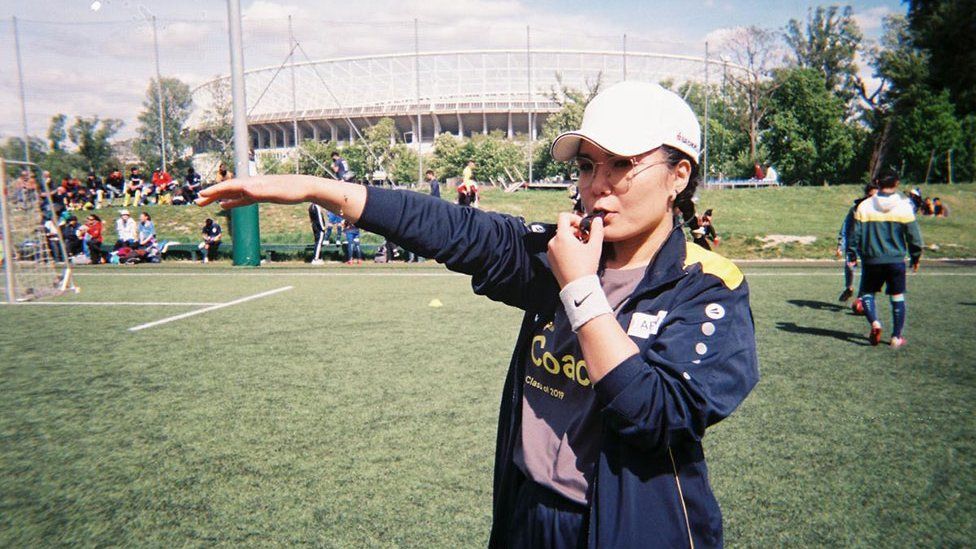A girl football player poses for the camera