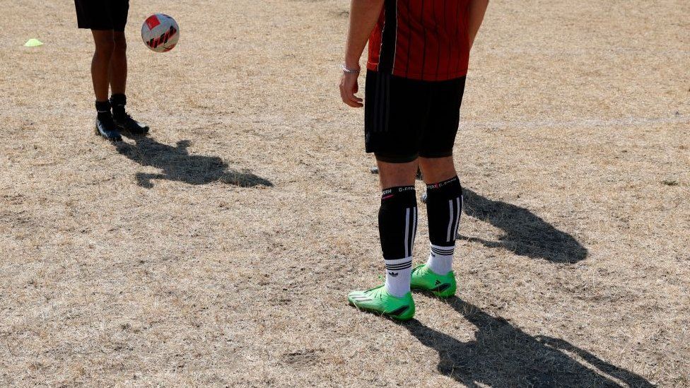 Footballers on dry grass