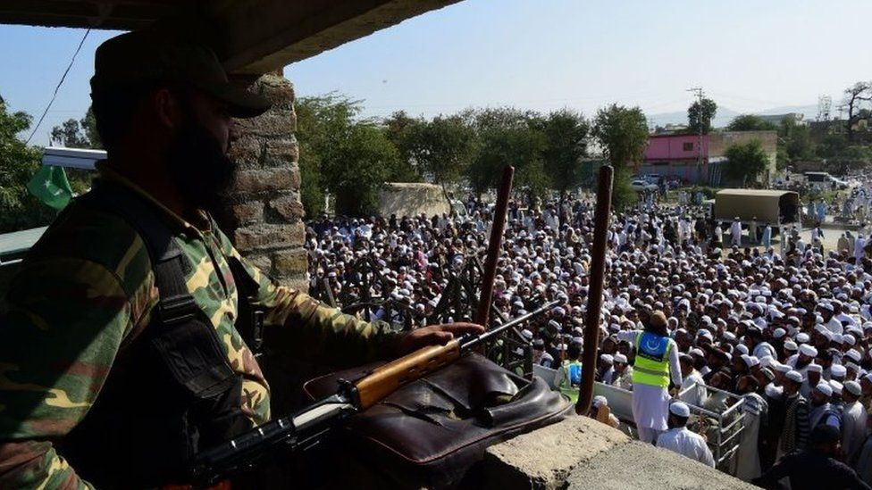 An armed member of the Pakistani security services stands guard during the funeral prayers in Akora Khattak. Photo: 3 November 2018