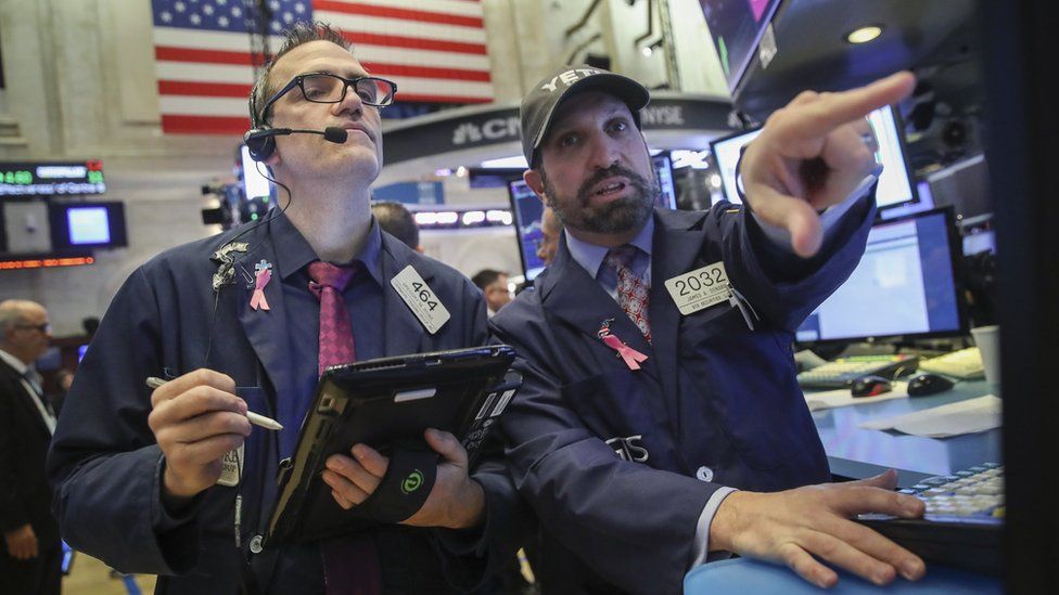 Traders and financial professionals work on the floor of the New York Stock Exchange (NYSE) at the opening bell, October 25, 2018 in New York City