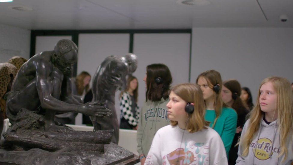 Students file past a statue at the Africa Museum in Belgium