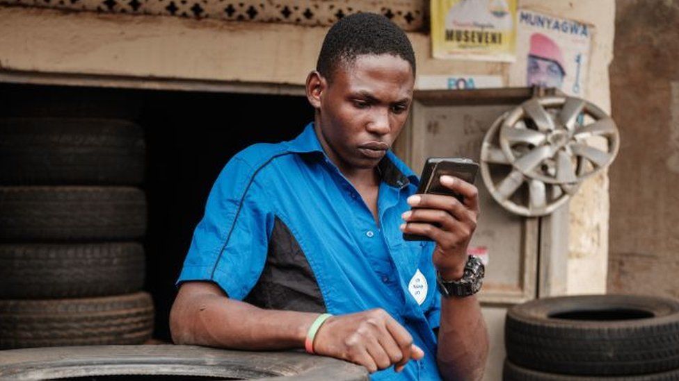 A man browses Facebook on his smart phone after the mobile internet went back online in Kampala