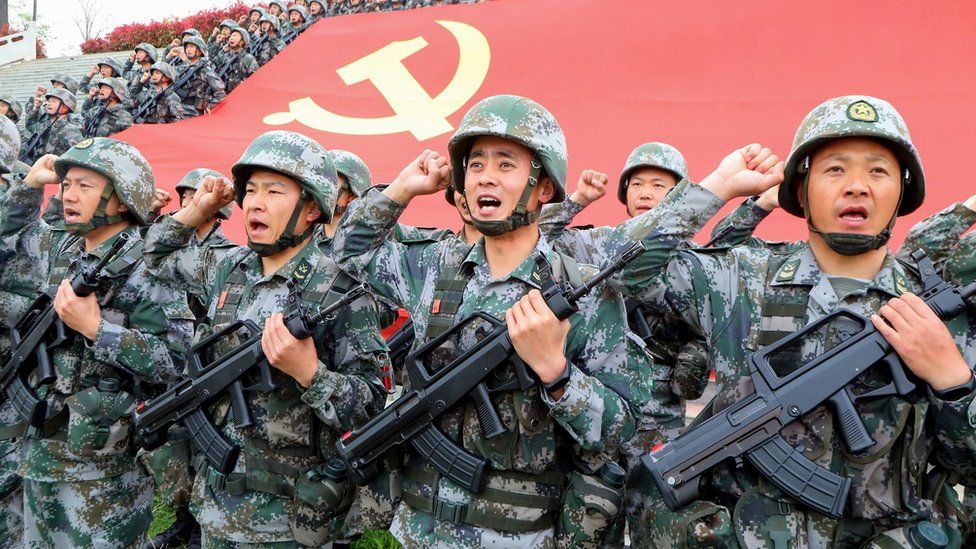 Miembros del Partido Comunista de China (PCCh) revisan el juramento de unirse al partido frente a la bandera del partido el 13 de abril de 2021 en Luoyang, provincia china de Henan.