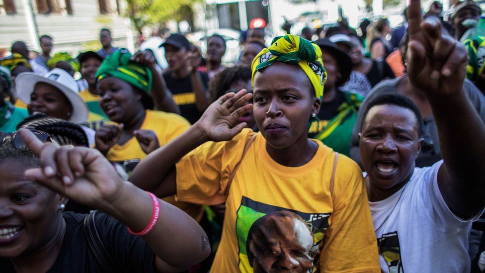 Supporters of the ANC and South Africa's new President Cyril Ramaphosa sing and dance after his swearing in outside the South African general assembly on 15 February 2018 in Cape Town
