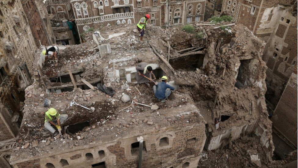 Workers demolish a building damaged by rain in the Unesco World Heritage site of the old city of Sanaa