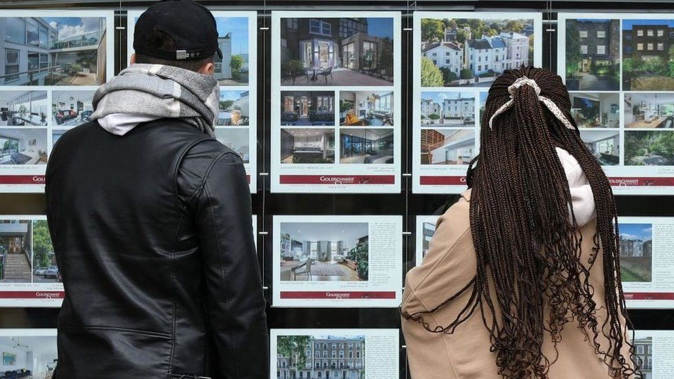 Young couple looking at an estate agent's window