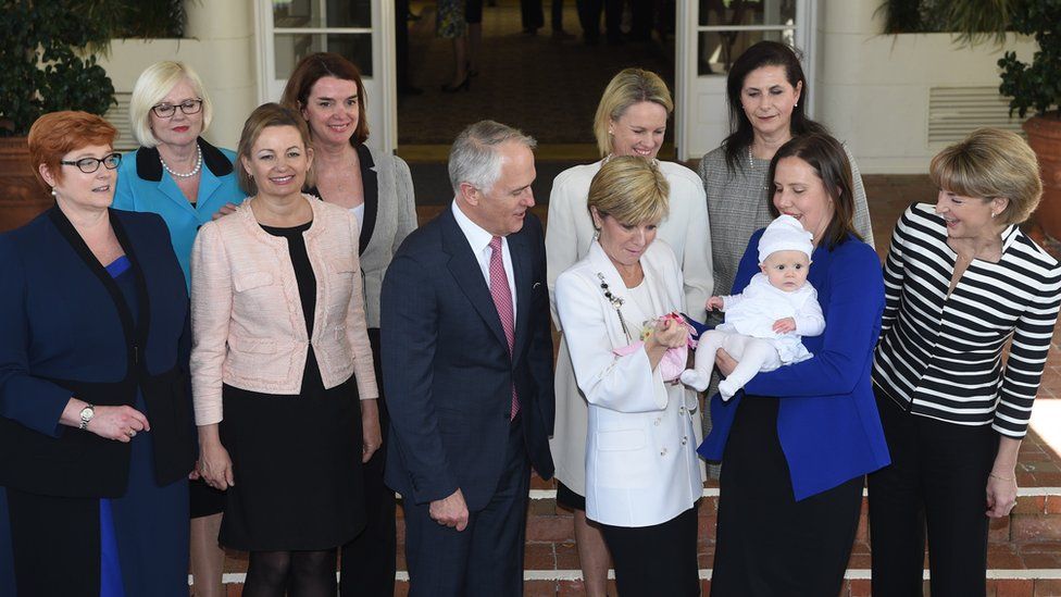 Malcolm Turnbull (centre) with his nine female ministers and one minister's baby