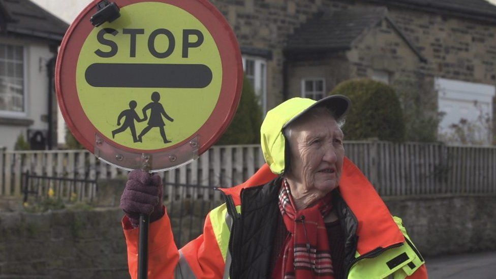 Lollipop lady holding up a Stop sign