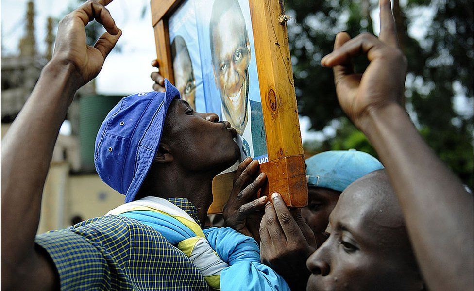 A suuporter kisses a portrait of Ugandan opposition leader Kizza Besigye during a welcome rally for Besigye in Kampala on 12 May 2011