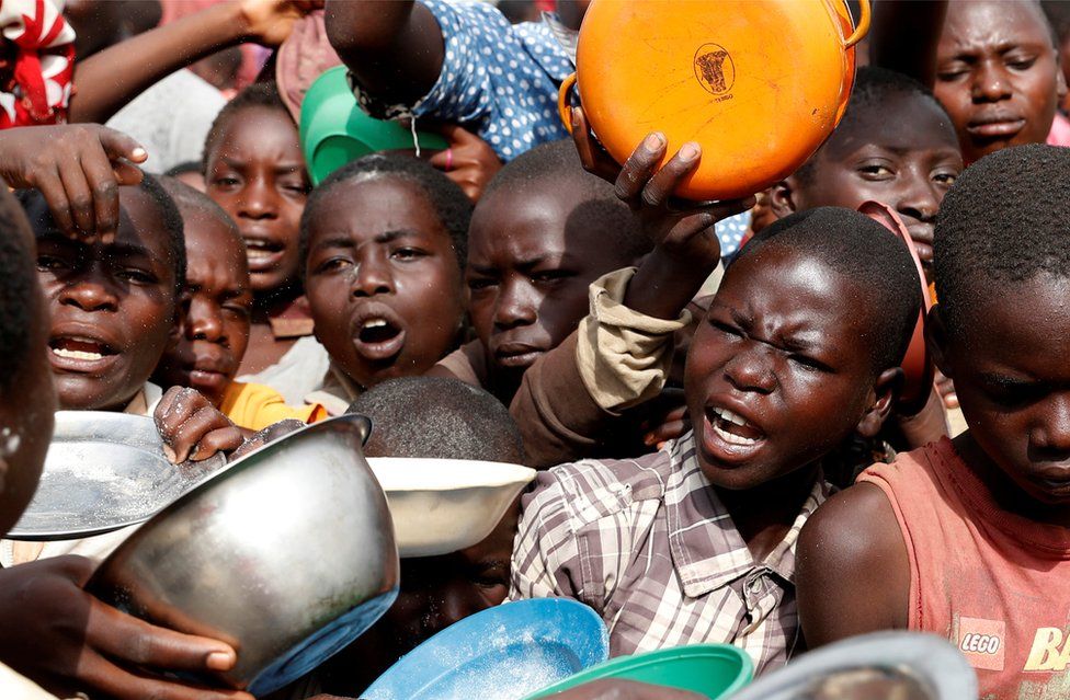 Internally displaced people wait for food distribution.
