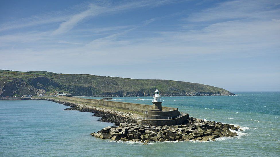 Fishguard Harbour wall and lighthouse with sea defences, Pembrokeshire