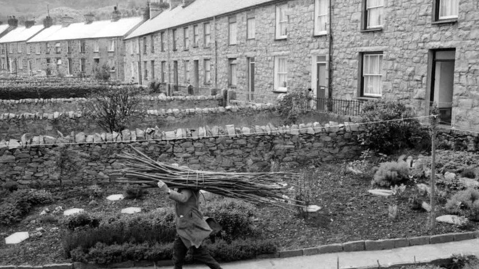 A man carrying sticks in Trefor