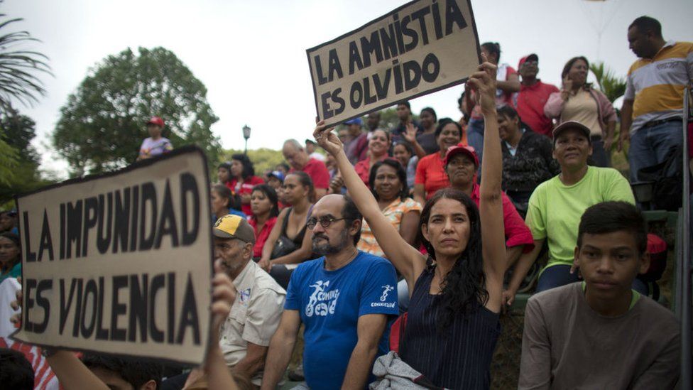 Supporters of President Maduro hold a sign up that reads "Amnesty is to forget". 7 Apr 2016