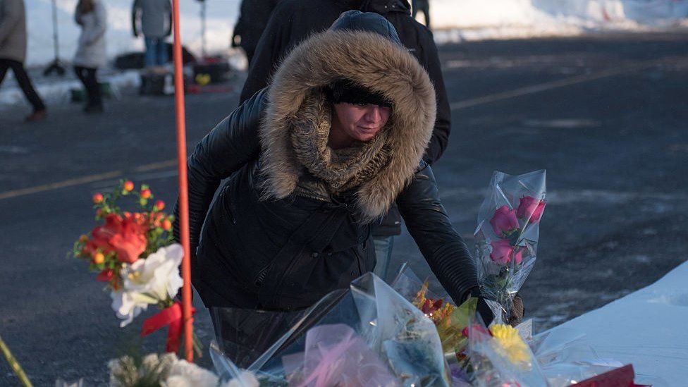 People place flowers at a makeshift memorial near the Islamic Cultural Center in Quebec City, Canada on January 30, 2017
