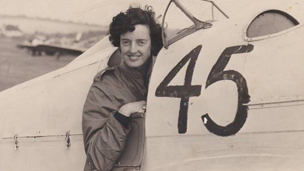 Sepia-coloured photograph of Freydis Sharland leaning out the cockpit of a Hawk Major aircraft with the number 45 painted on the side