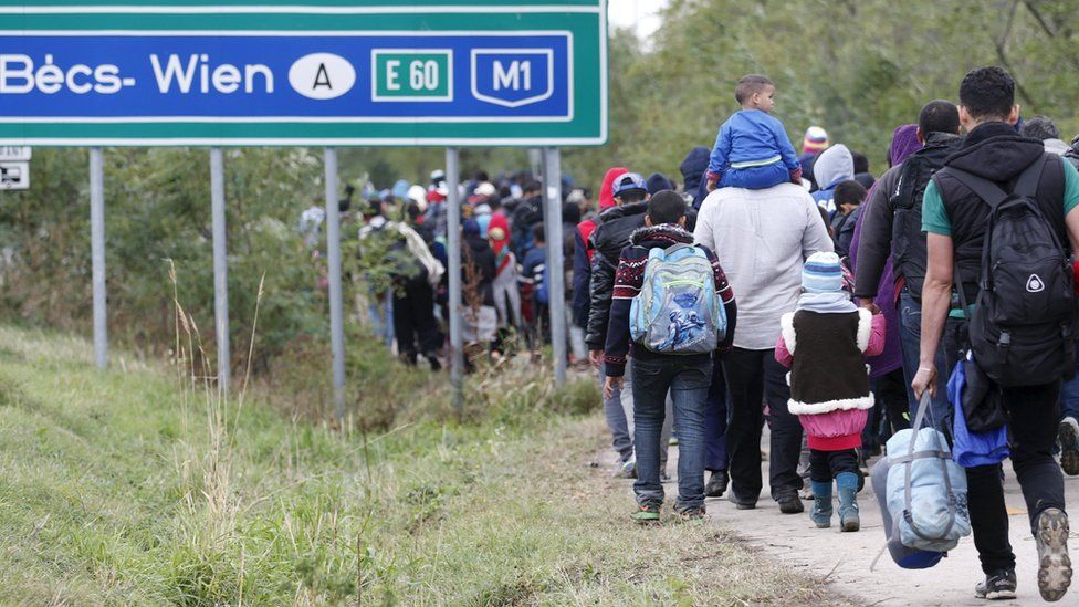 Migrants walk towards the Austrian border in Hegyeshalom,