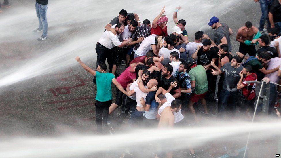 Lebanese protesters are sprayed with water during a protest in Beirut on 23 August, 2015