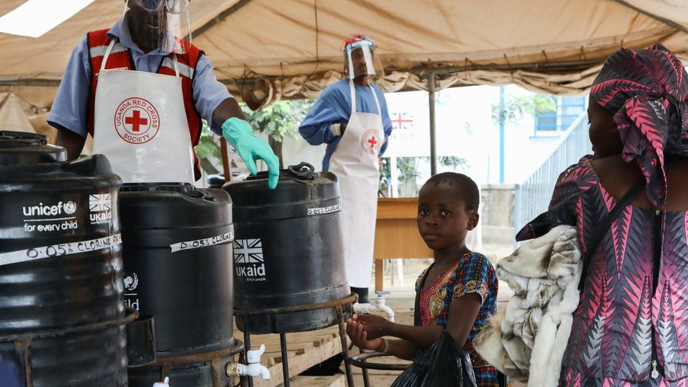 A young girl washes her hands in an Ebola prevention checkpoint supported by UK aid at a Ugandan border crossing point with the DRC, August 2019