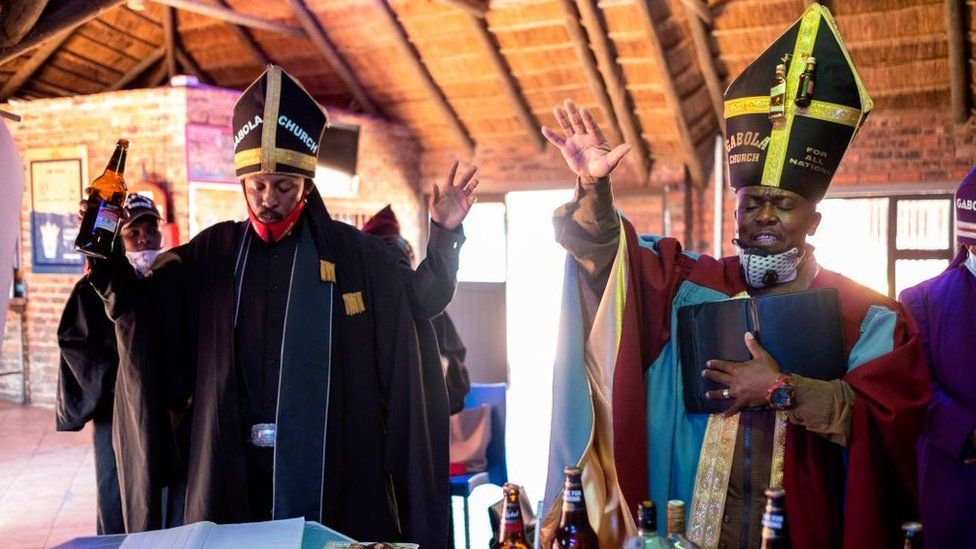 Tsietsi Makiti (R) the founder and leader of Gabola church gestures while praying during the Sunday sermon at Bunny's Tavern in Evaton on August 30, 2020.