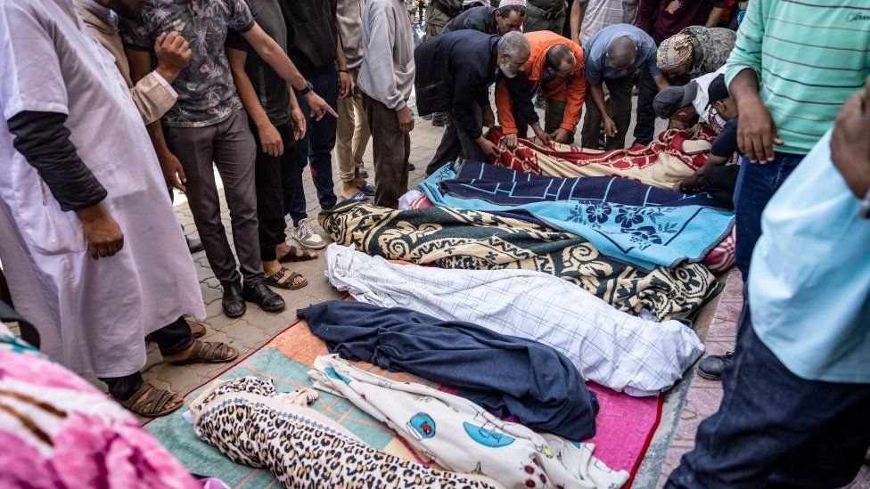 Relatives mourn in front of the bodies of victims killed in the earthquake in Moulay Brahim, in al-Haouz province