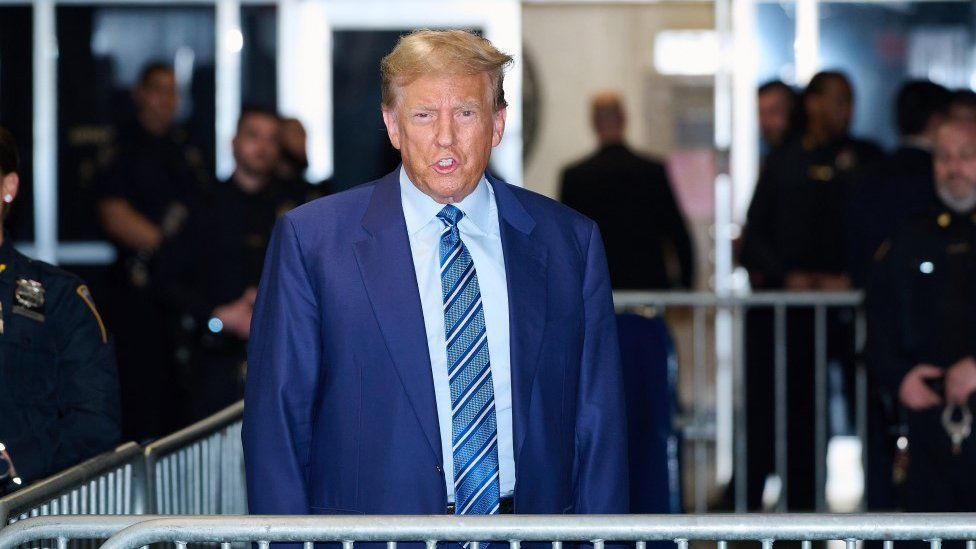 Trump greets media outside court