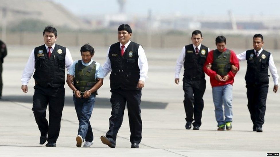 Dionisio Ramos (2nd L), also known as Comrade Yuri, and Alexander Alarcon Soto, also known as Comrade Renan, are escorted by police officers after arriving at a military airport in Callao, Peru, August 10, 2015. Ramos and Alarcon, suspected members of Peru"s leftist Shining Path insurgency, were arrested in Concepcion Valley in Cuzco this week.