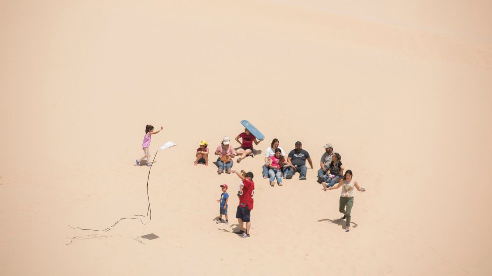 Families fly kites in the Samalayuca dunes