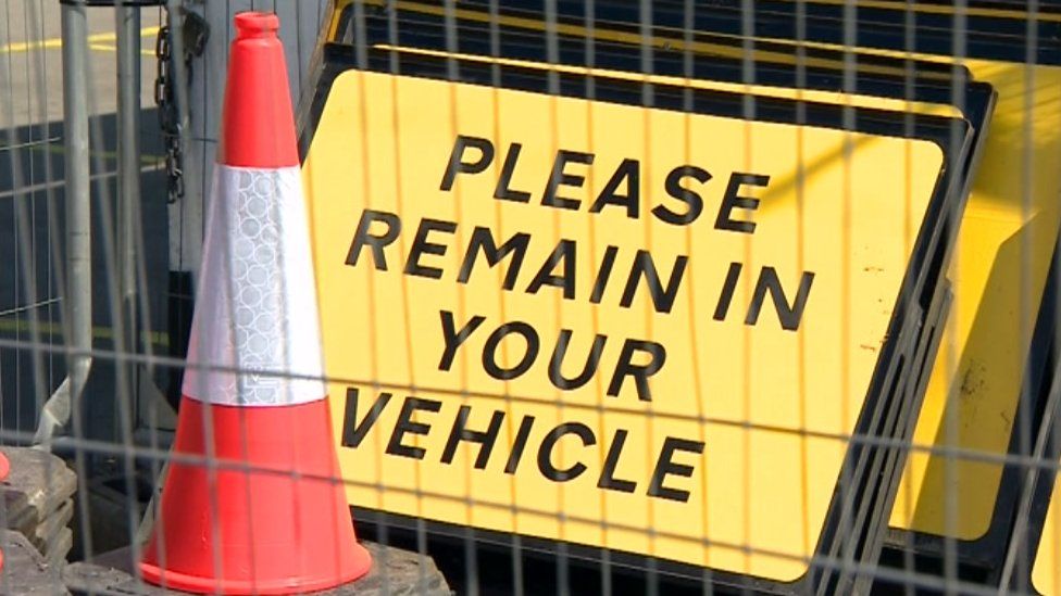 Please remain in your vehicle sign