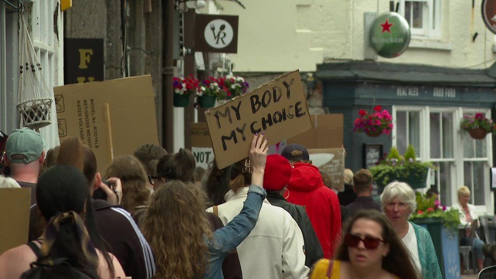 March through Plymouth's streets with placards