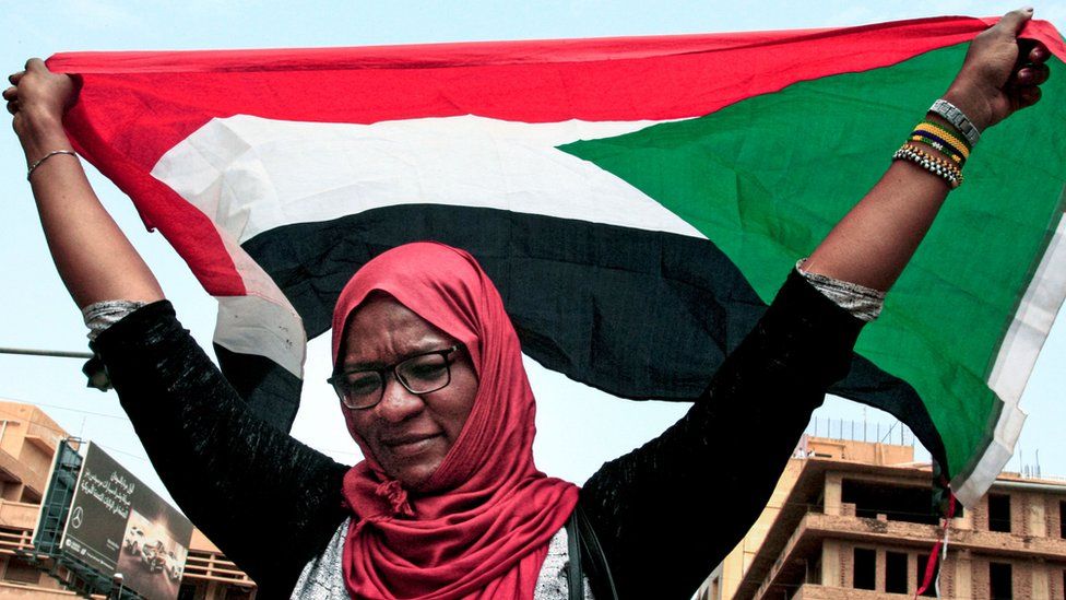 A woman waves a Sudanese national flag during a mass demonstration on 12 September 2019