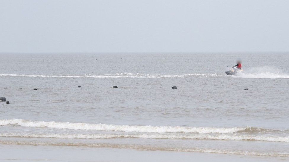 Water scooter and seals off Horsey beach in Norfolk