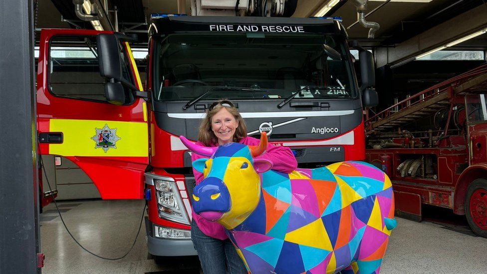 An ox sculpture in front of a fire and rescue vehicle