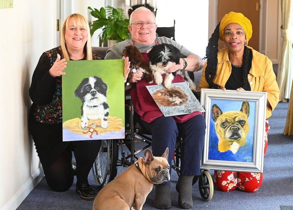 Charles Tame with his dog paintings, and the pets' owners