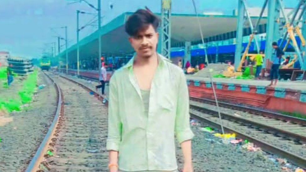 Raja Sahani de pie en una vía de ferrocarril