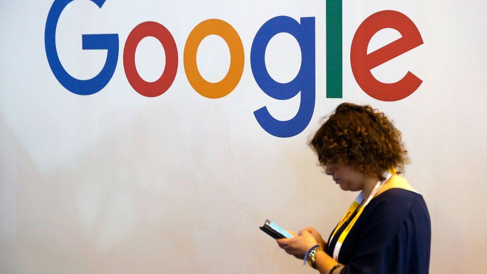 A visitor walks in front of a Google logo during a show at Parc des Expositions in May 2018