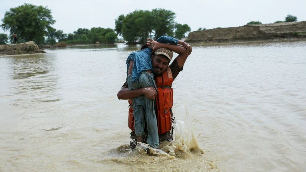 A soldier of Pakistan army rescues a child from the flood affected Rajanpur district, in the Punjab province of Pakistan, on August 2, 2022