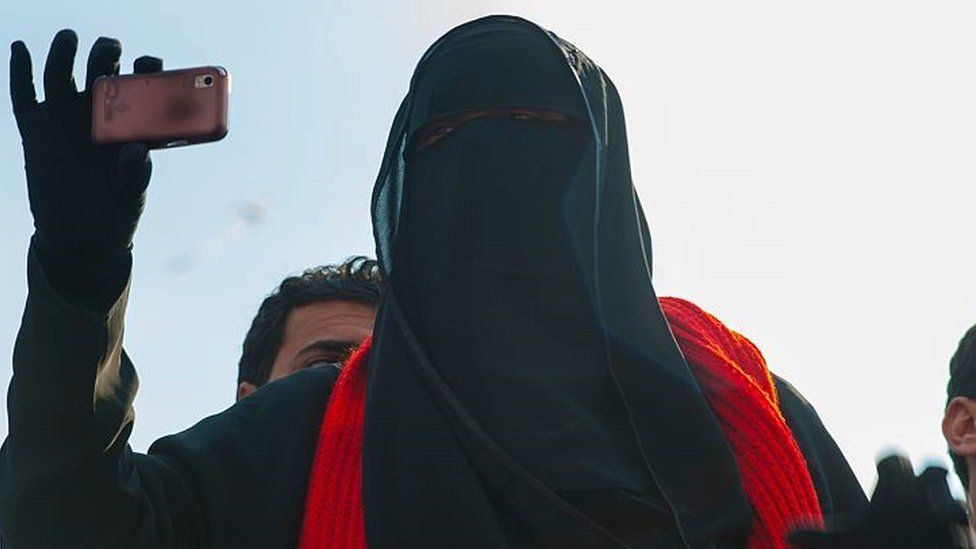Девушка с полной чадрой фотографирует на свой смартфон на площади Тахрир в Каире во время восстания против президента Мубарака