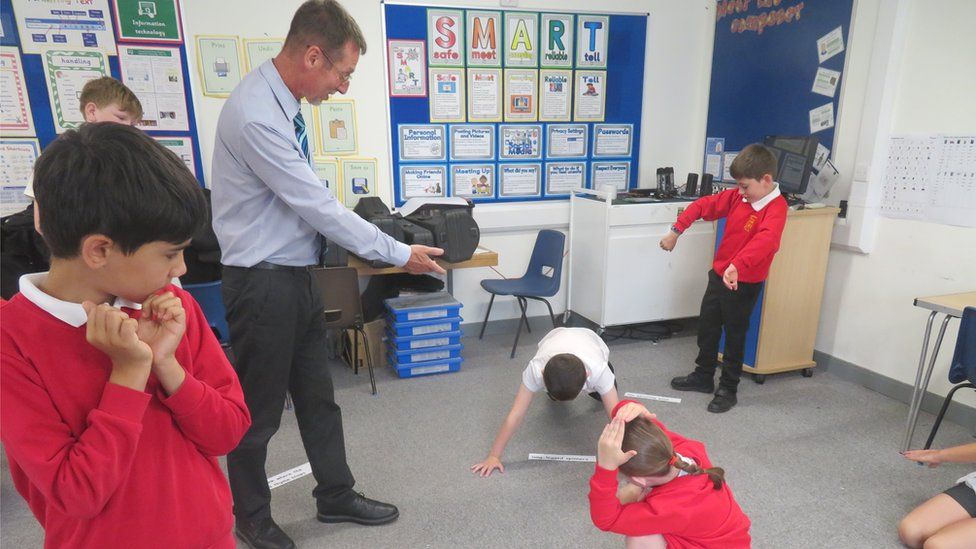 Springhead Primary School's head teacher Brian Anderson with 10 year-olds creating a "word carpet" from A Midsummer's Night Dream, that describe a forest