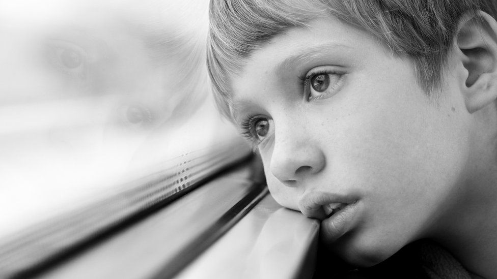 Young boy looking out of a window