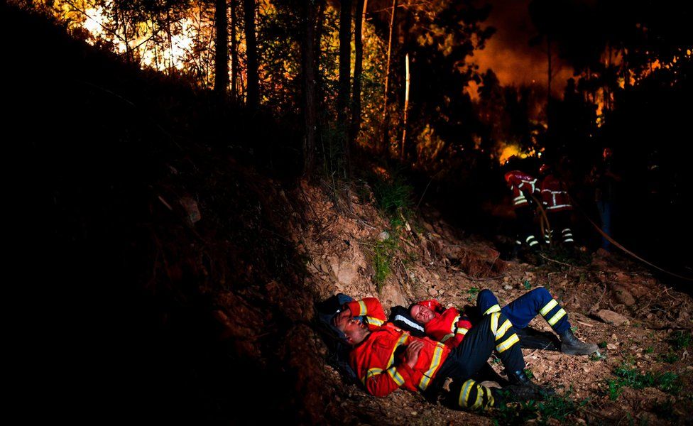 Firefighters rest during a wildfire at Penela, Coimbra, central Portugal, on June 18, 2017