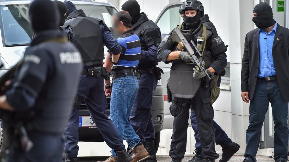 A suspected member of the Islamic state group is led away by Austrian police