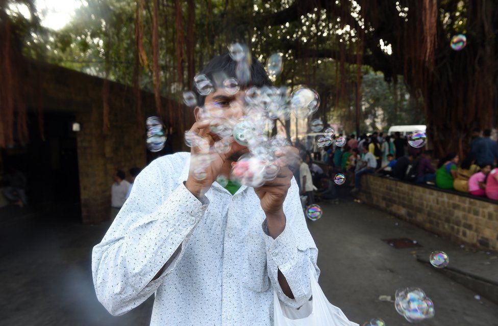 A unemployed young Indian man sells self-made bubble making device