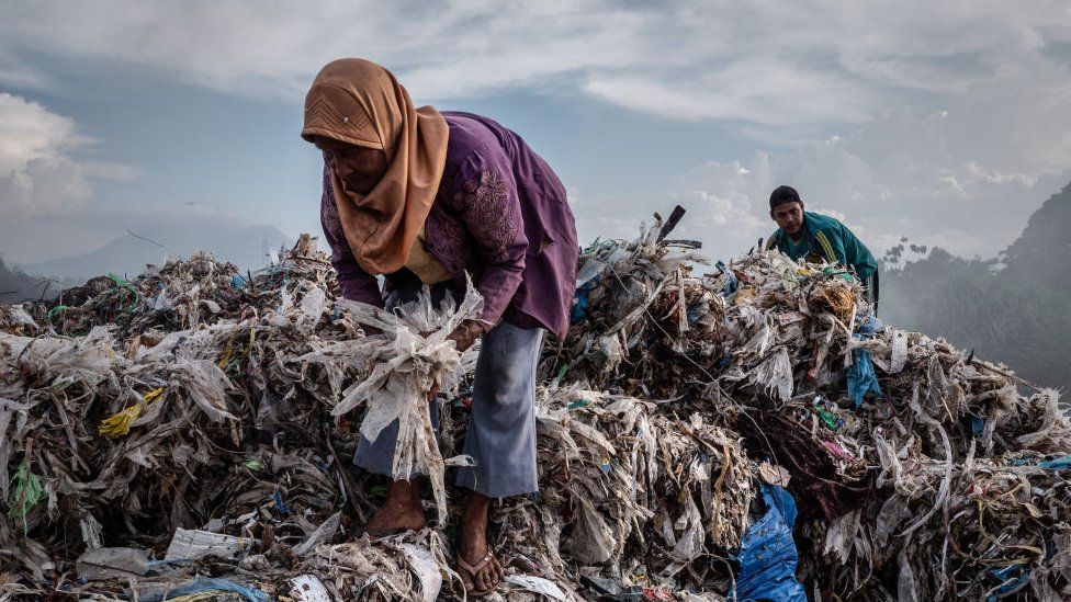 A woman collecting plastic to recycle at a import plastic waste dump in Mojokerto, East Java, Indonesia in December 2018.