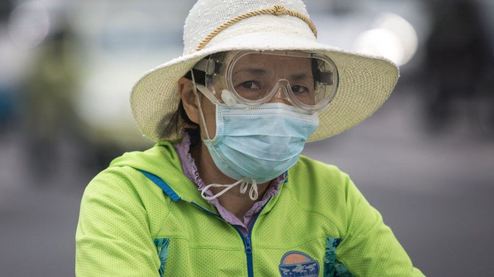 A women wears a mask while riding a bicycle on May 11, 2020 in Wuhan, China.